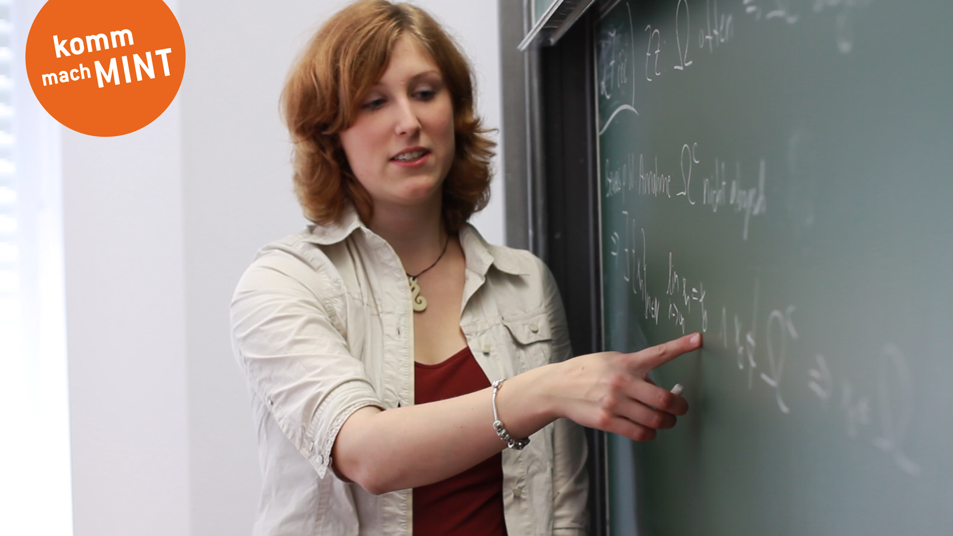 Studentin steht an Tafel